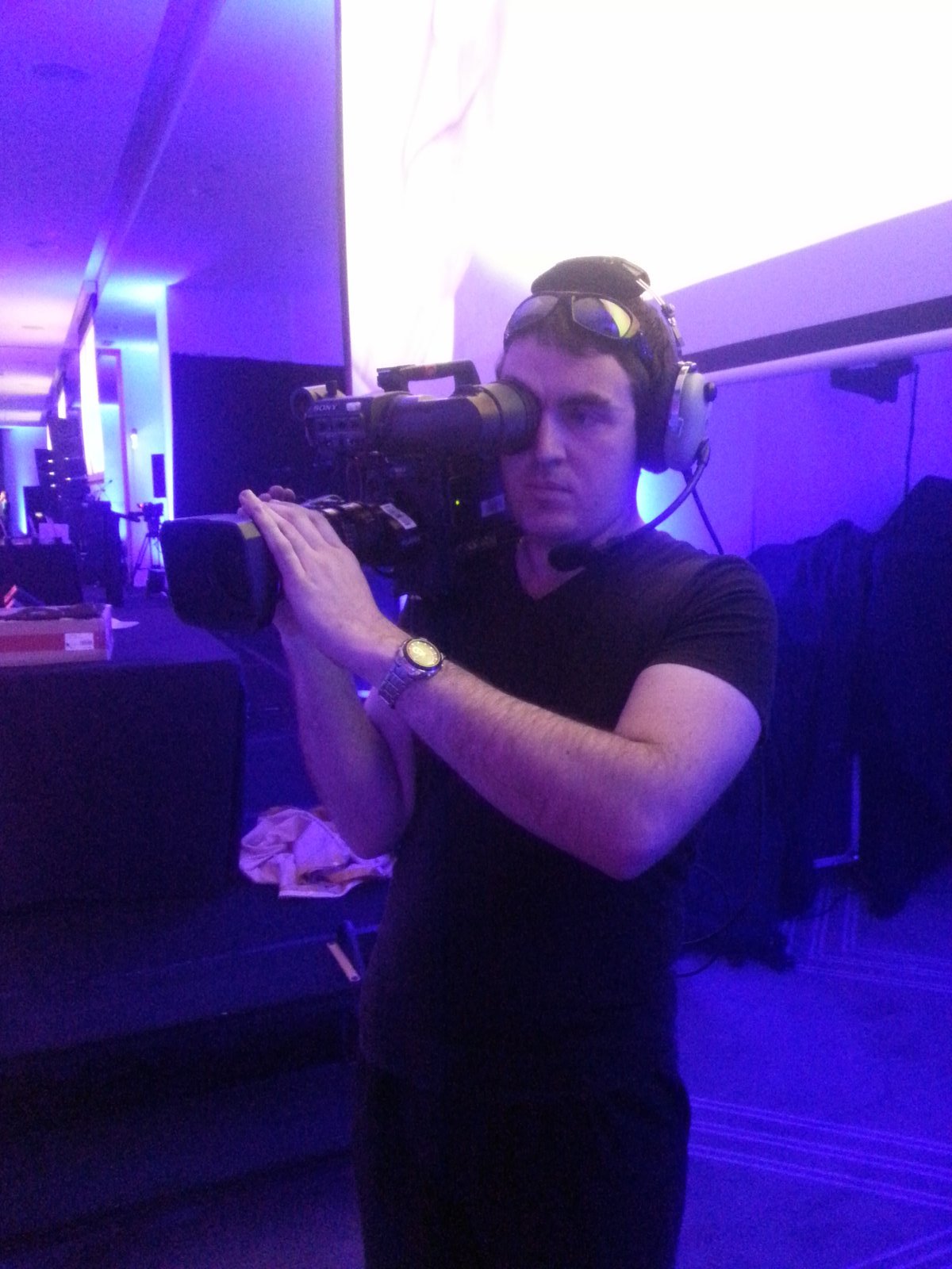 Camera operator working a formal awards night under stage lighting