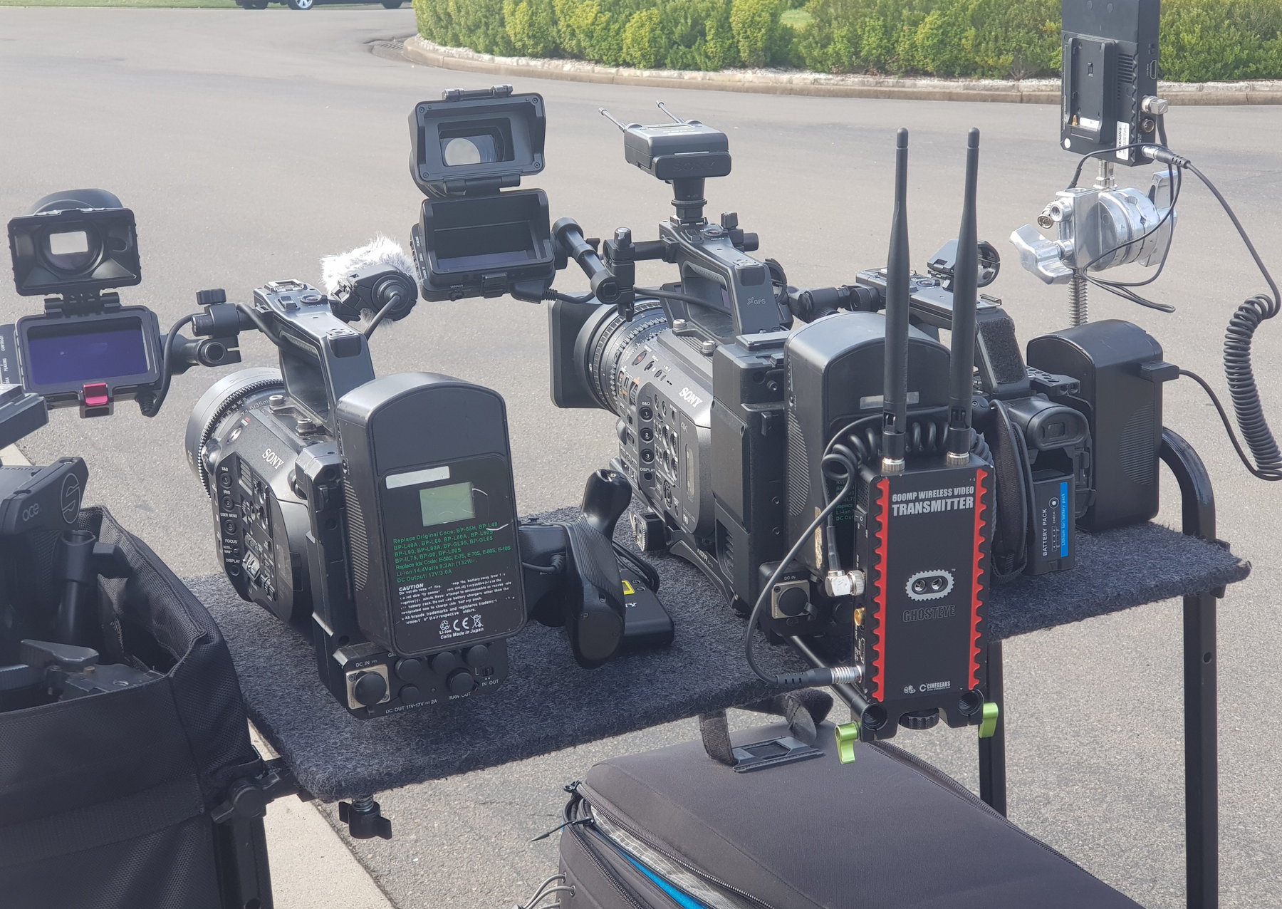 Three broadcast cameras lined up on a road