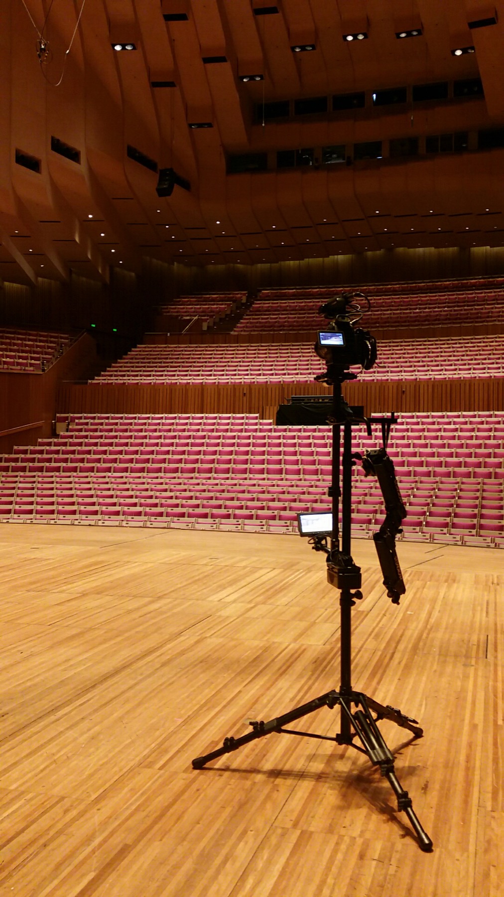 Camera on a tripod in an empty concert hall