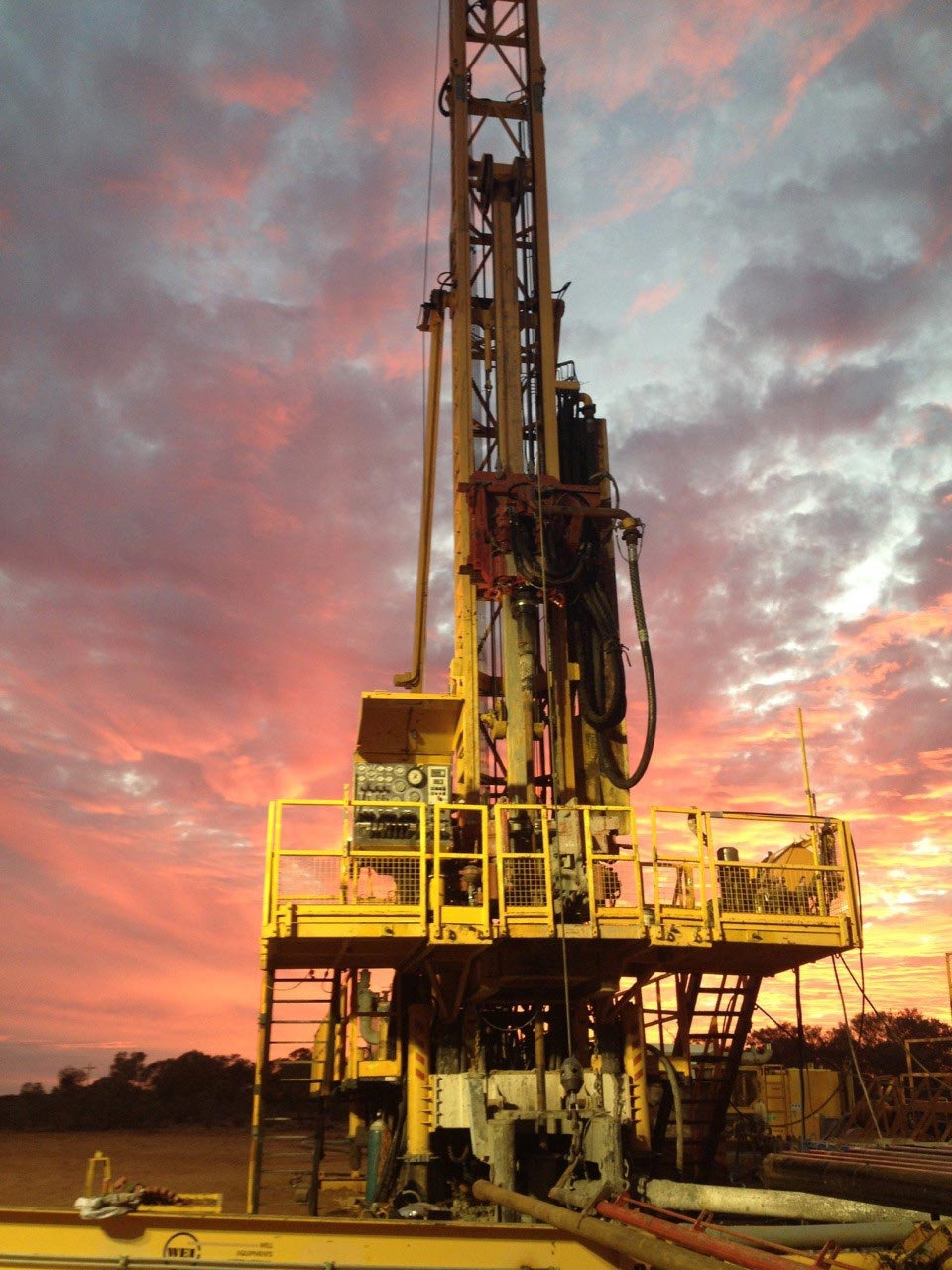 A drill rig against a sunset sky