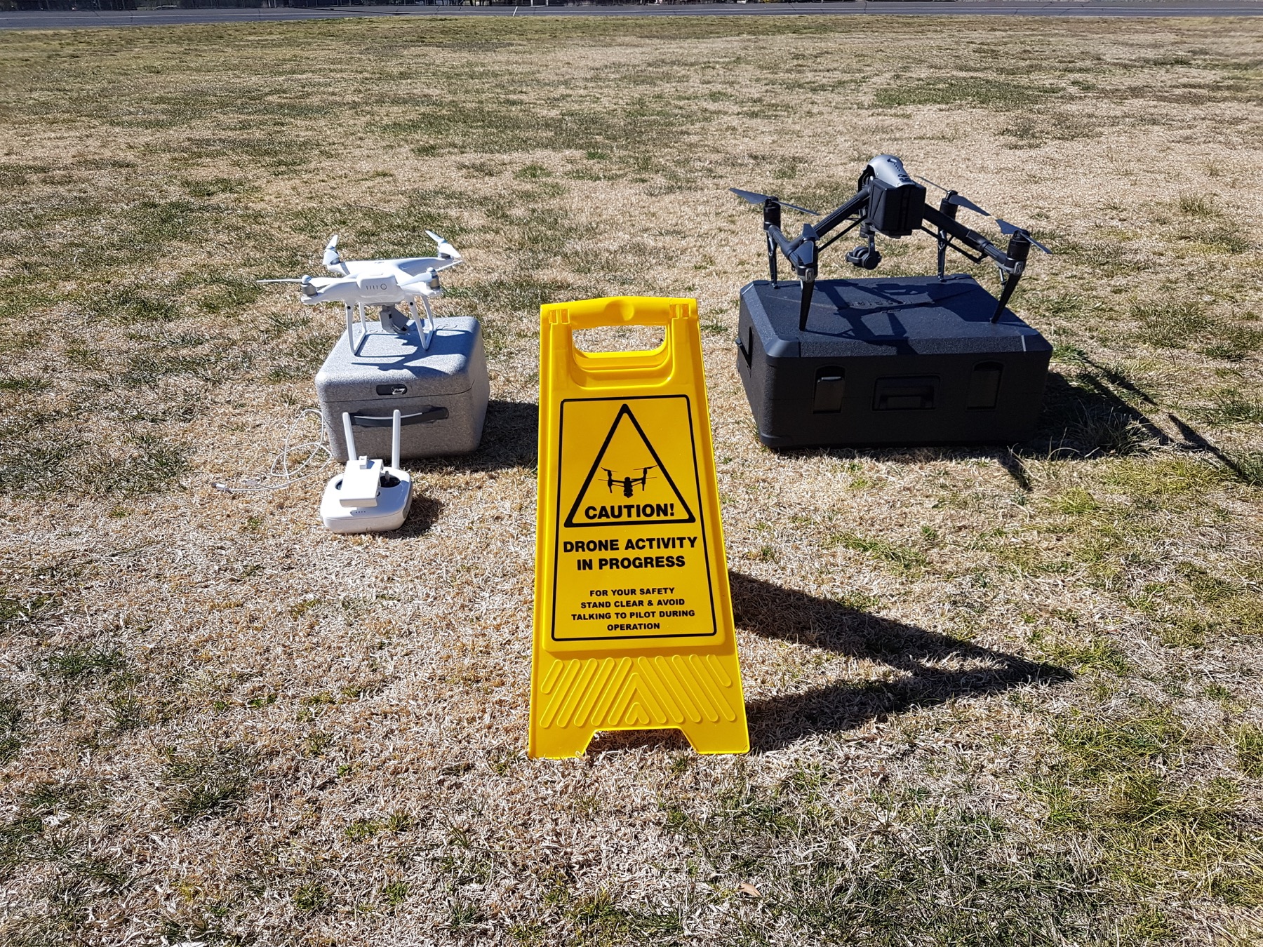 Drone kit laid out beside a Caution Drone Activity In Progress sign