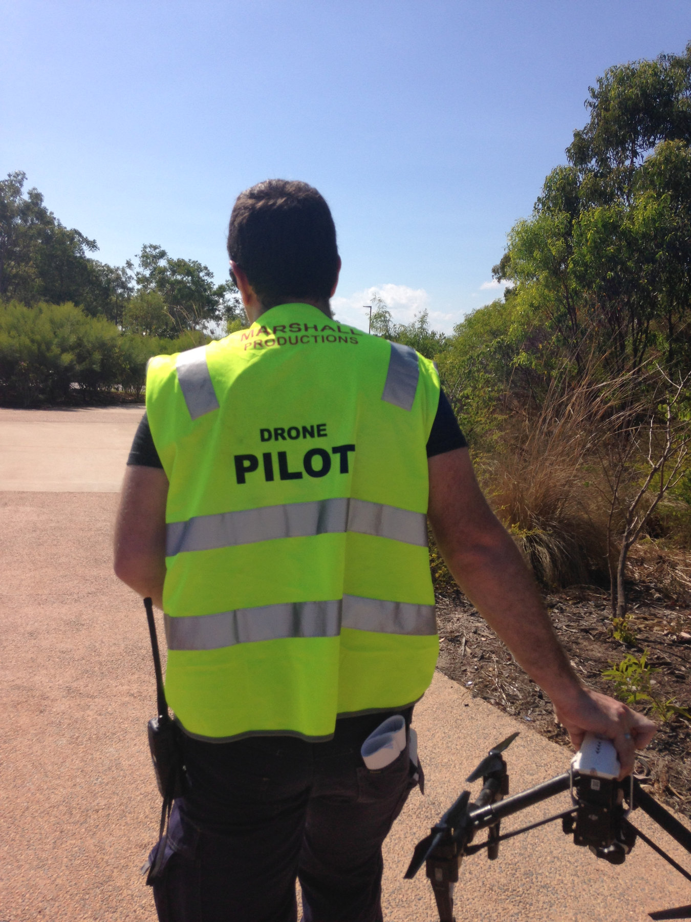 Evan from behind wearing a hi-vis Drone Pilot vest at a launch site