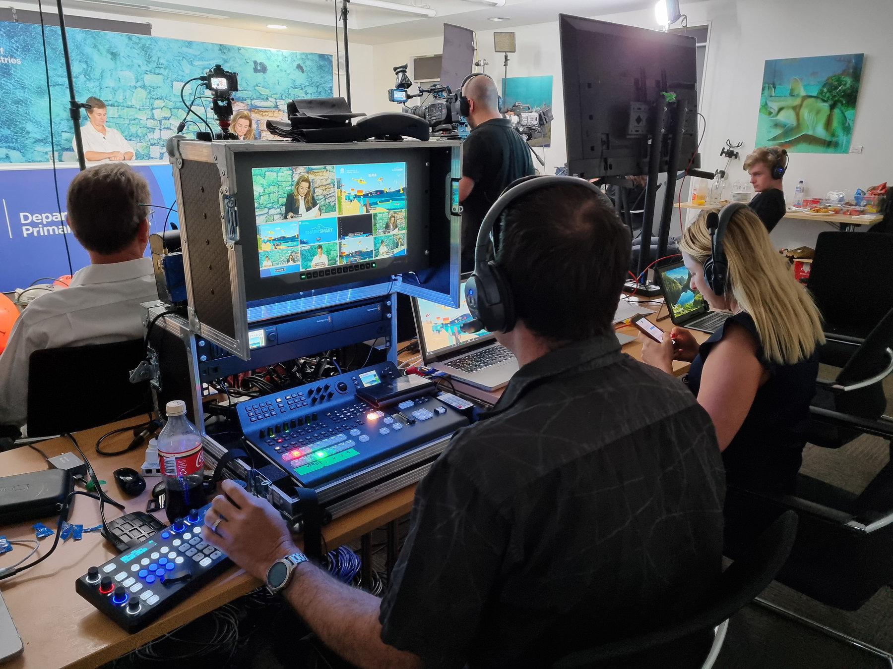 Evan directing a live stream at the vision mixer with headphones on