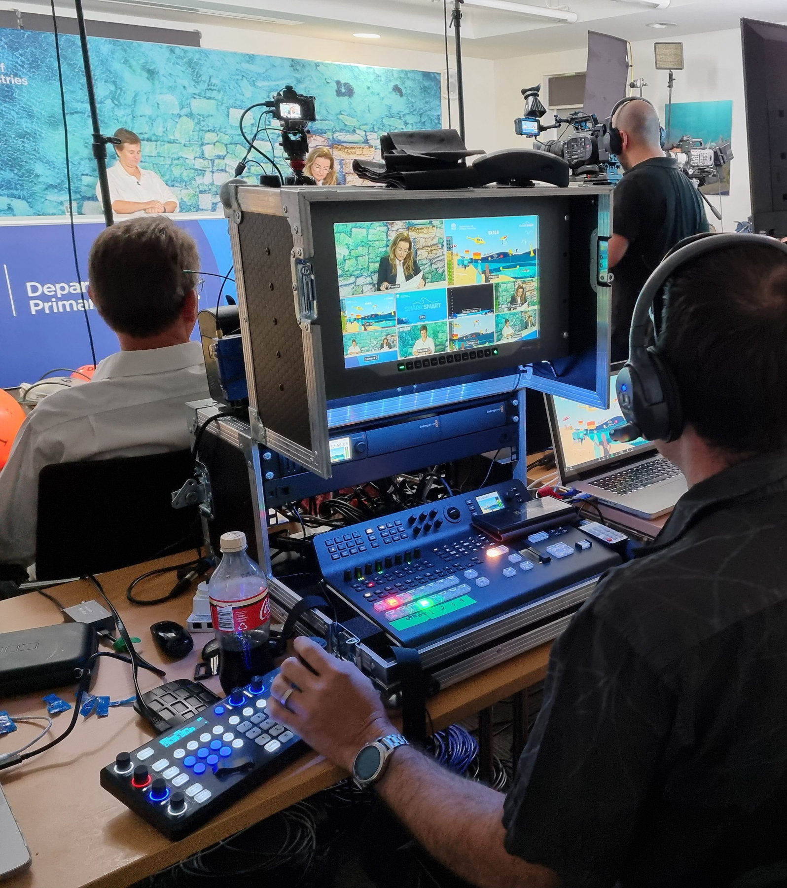 Evan Zell at the vision mixer with headphones on, directing a live stream