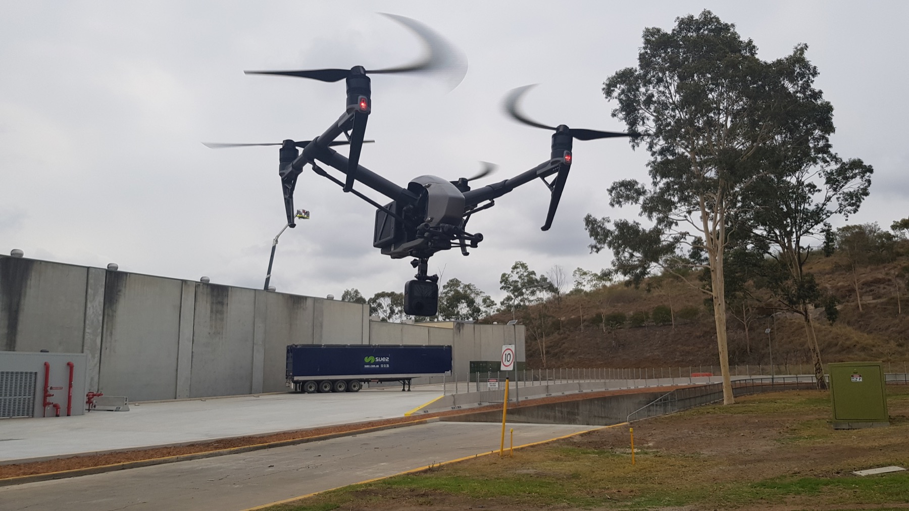 DJI Inspire in flight above a truck depot