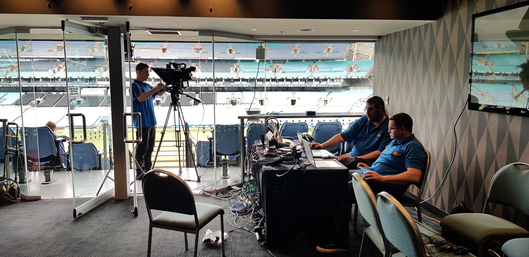 Evan at a broadcast desk in stadium seating