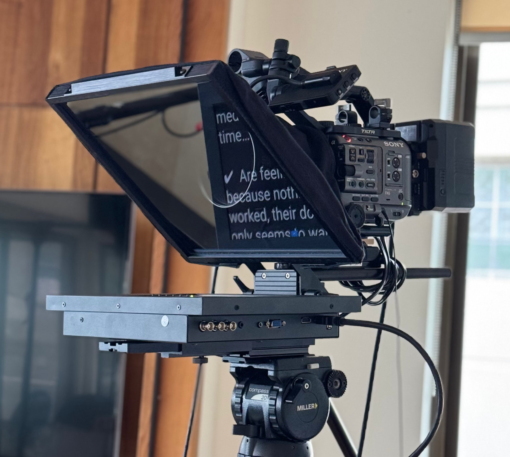 A camera mounted teleprompter rig on a tripod
