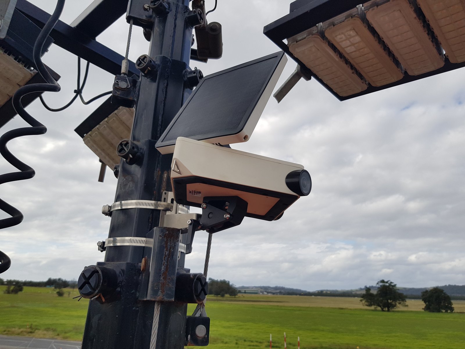 A solar powered time-lapse camera on a pole overlooking a construction site
